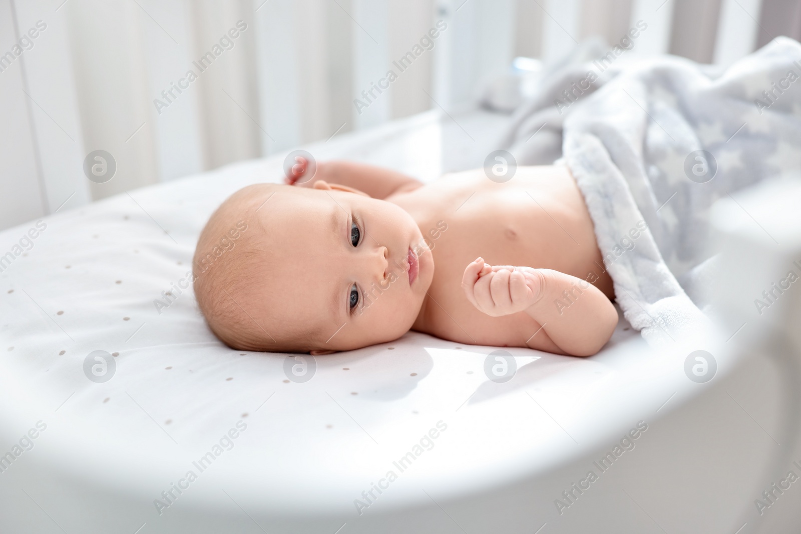 Photo of Cute little baby lying in crib at home