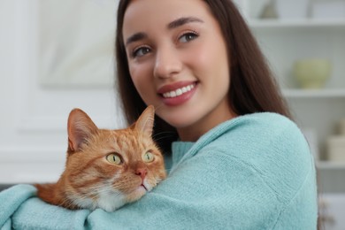 Beautiful woman with cute cat at home