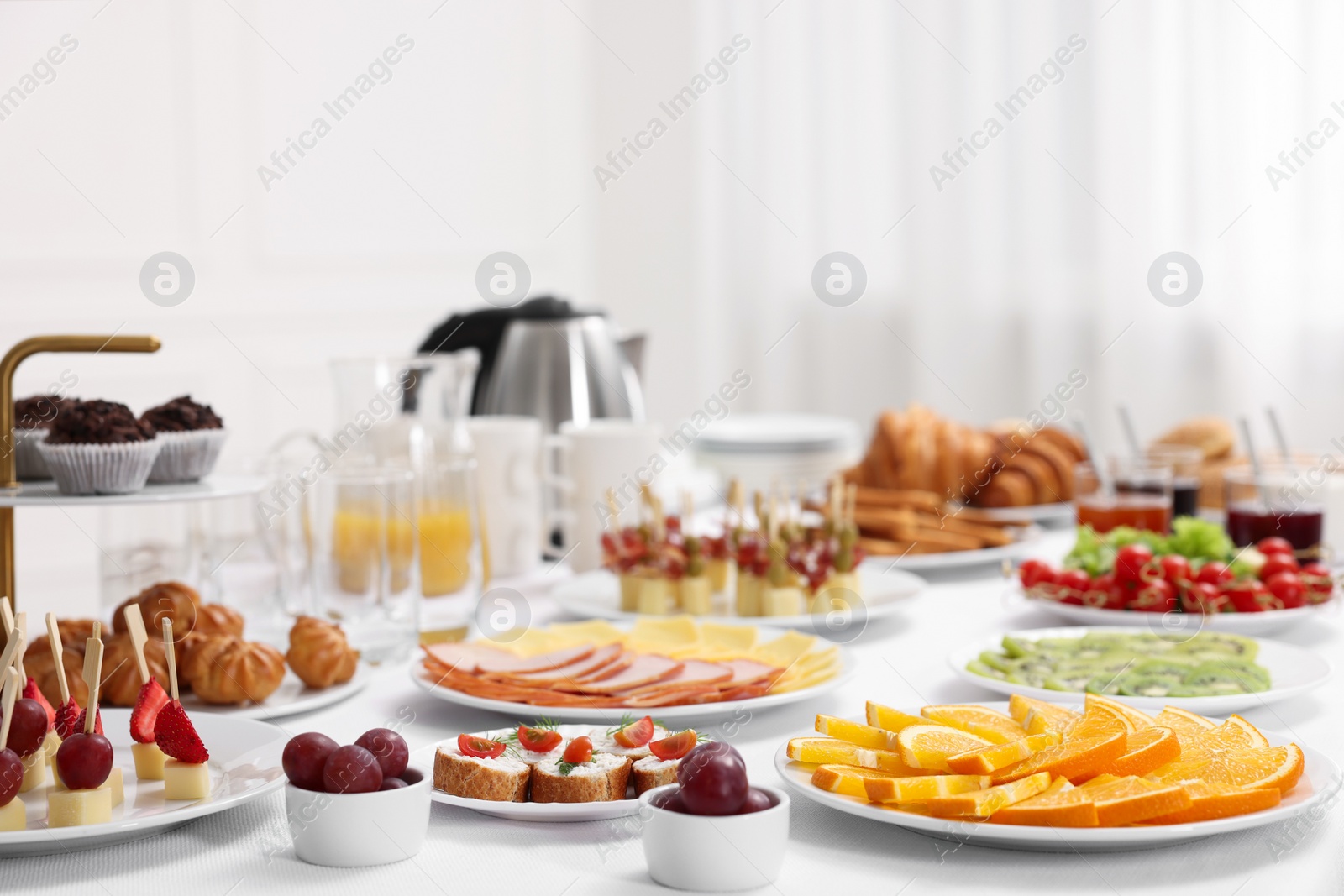 Photo of Different meals served on white table indoors. Buffet menu