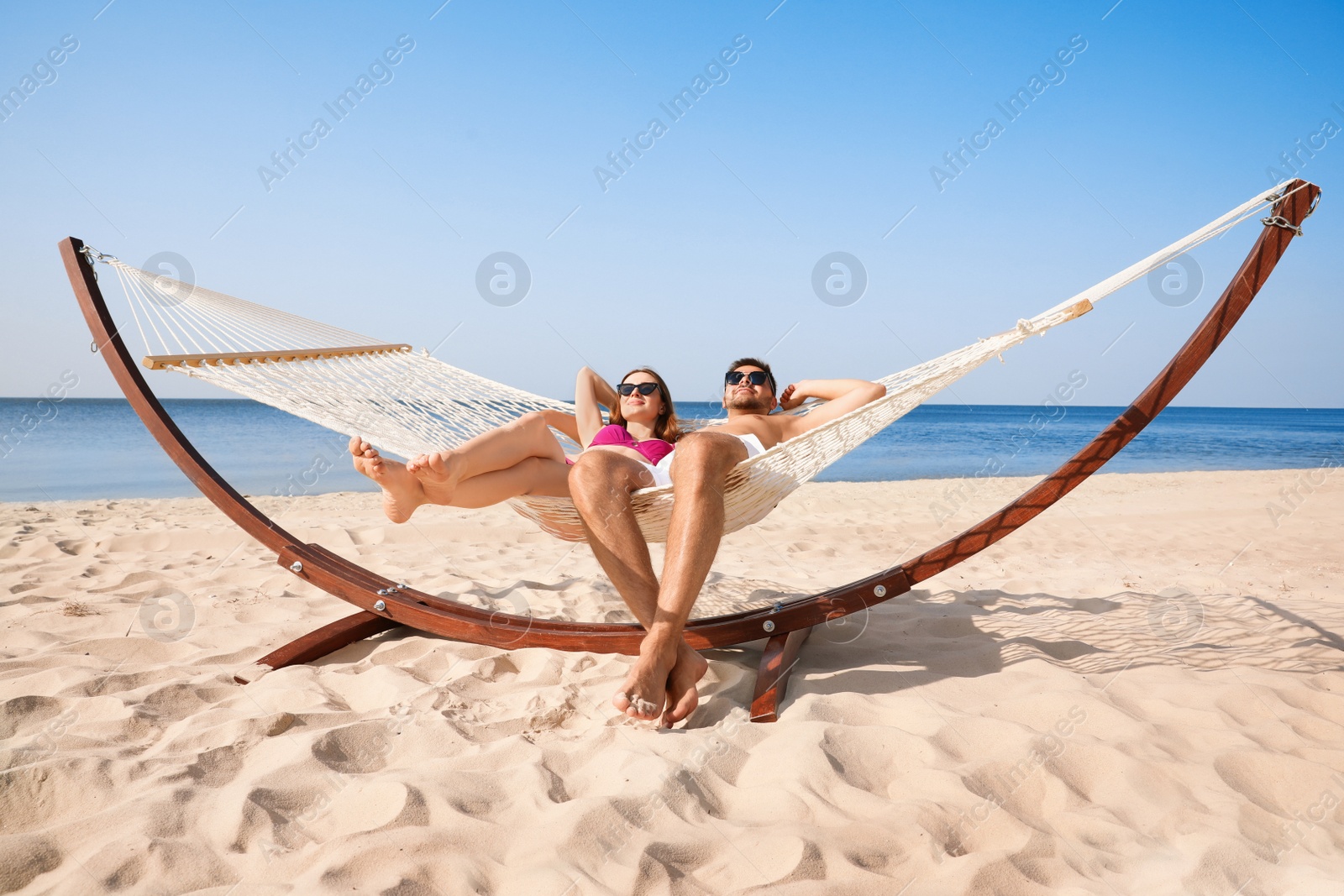 Photo of Young lovely relaxing in hammock on beach