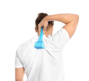 Photo of Young man scratching back with toy rake on white background. Annoying itch