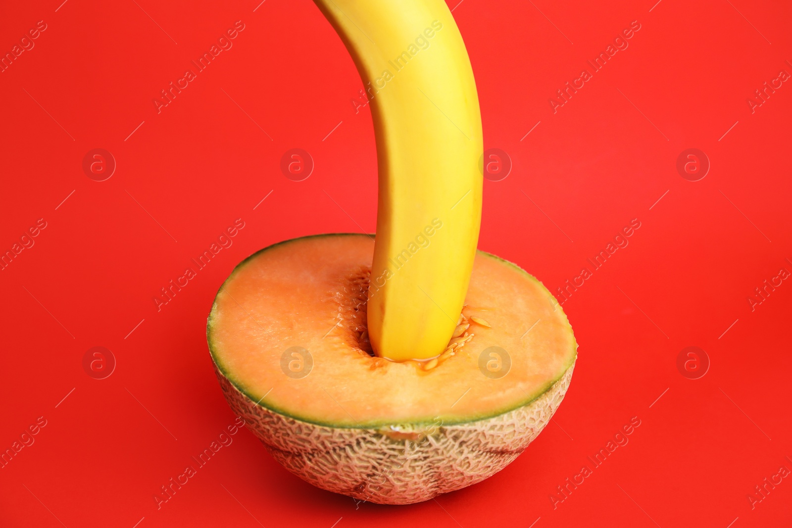 Photo of Fresh banana and melon on red background. Sex concept