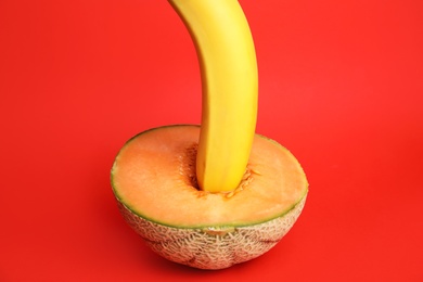 Photo of Fresh banana and melon on red background. Sex concept