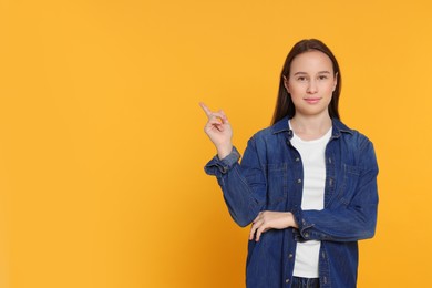 Portrait of teenage girl on orange background. Space for text