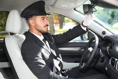 Young handsome driver in luxury car. Chauffeur service