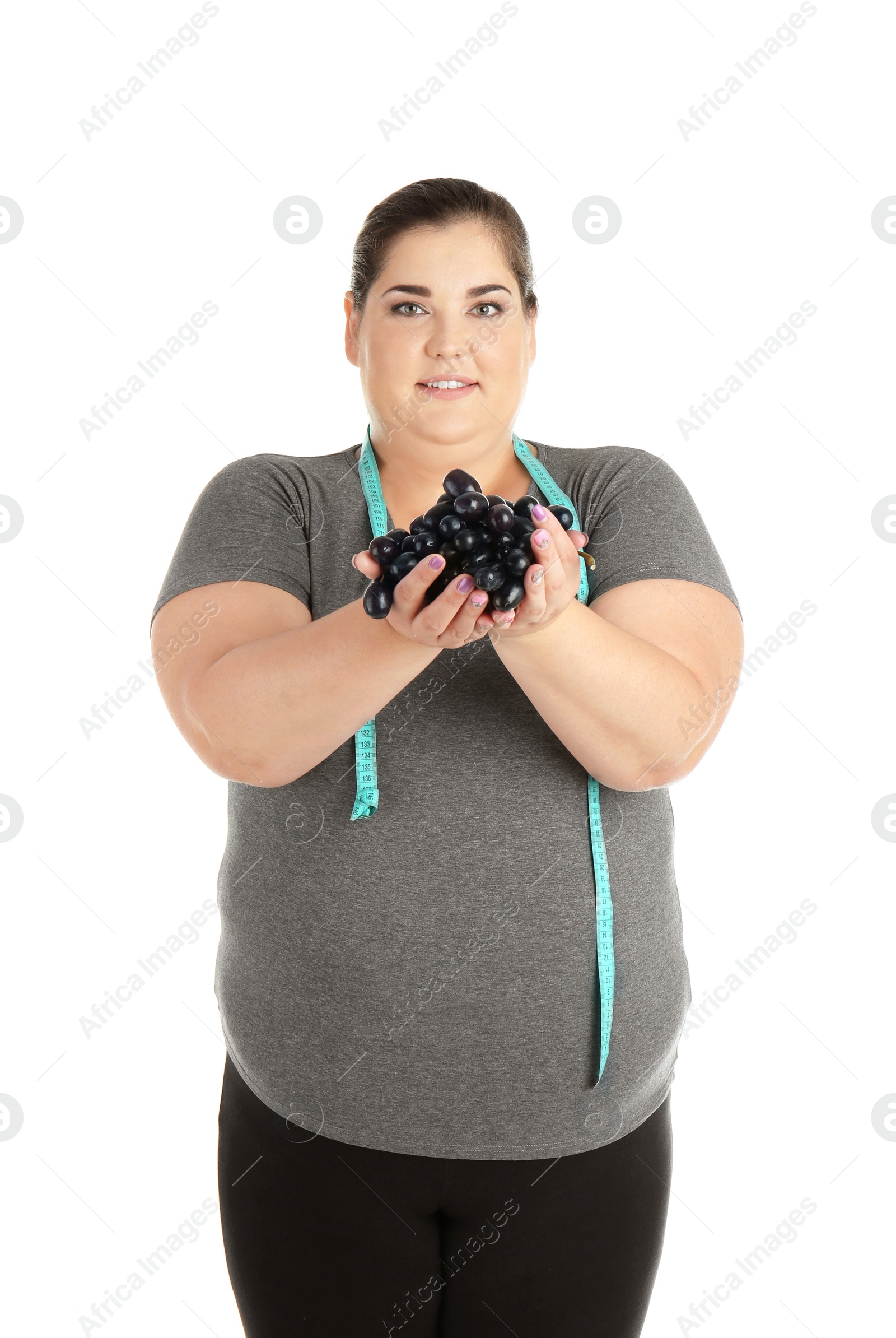 Photo of Overweight woman with grapes and measuring tape on white background