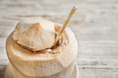 Photo of Fresh coconut drink in nut on wooden background