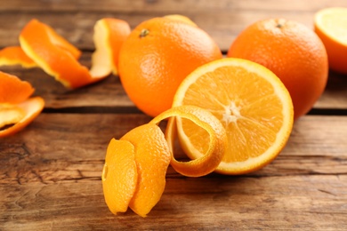 Photo of Orange fruits with peels on white wooden table