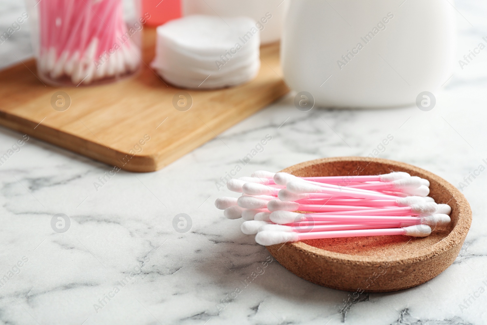 Photo of Plate with cotton swabs on marble table. Space for text