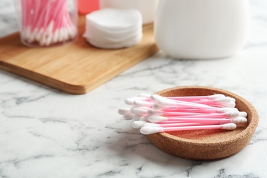 Plate with cotton swabs on marble table. Space for text