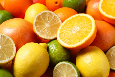 Different fresh citrus fruits as background, closeup