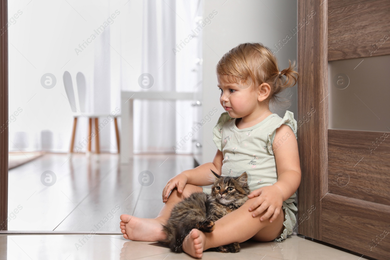 Photo of Cute little child with adorable pet on floor at home