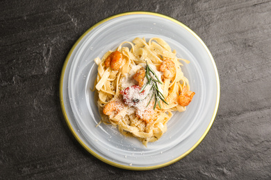 Delicious pasta with shrimps on black table, top view