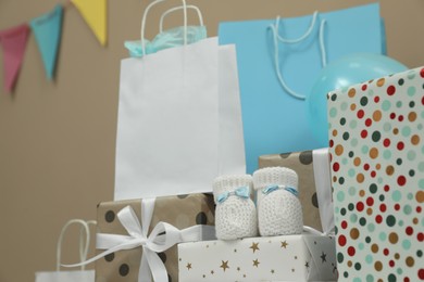 Photo of Baby shower party. Booties, many gift boxes and bags indoors