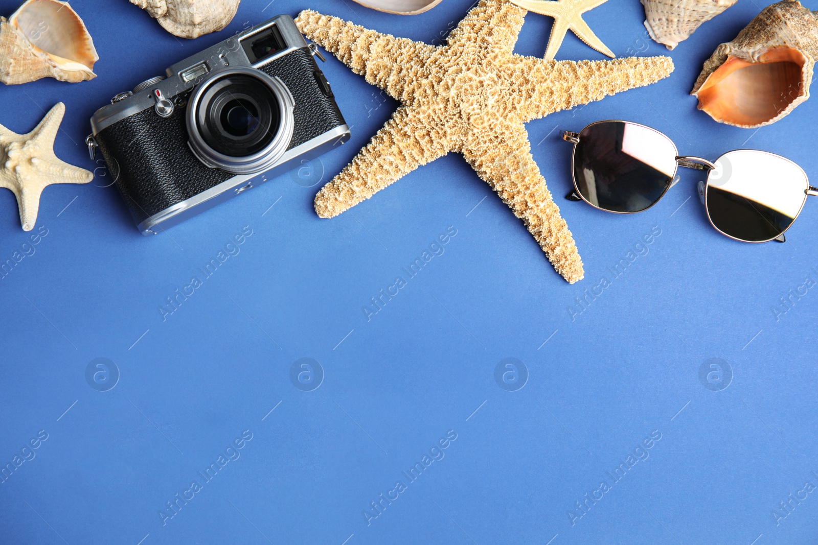 Photo of Flat lay composition with beach objects on blue background. Space for text