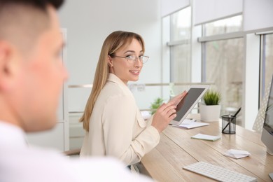 Photo of Young woman flirting with her colleague during work in office