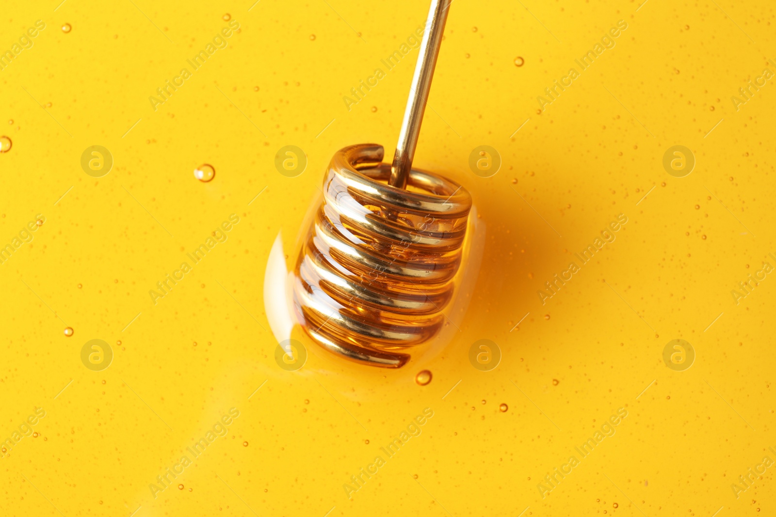 Photo of Dipper and golden honey, closeup. Natural sweetener