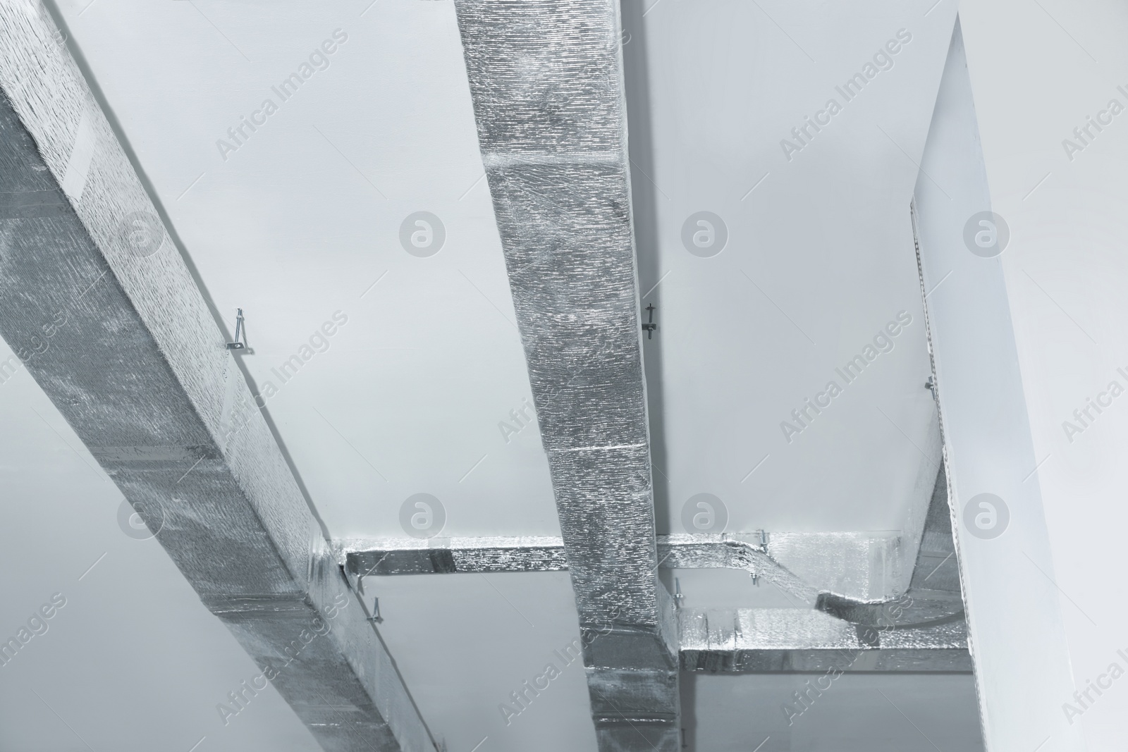 Photo of Ceiling with ventilation system indoors, low angle view