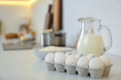 Photo of Fresh eggs and dairy products on countertop in modern kitchen. Space for text