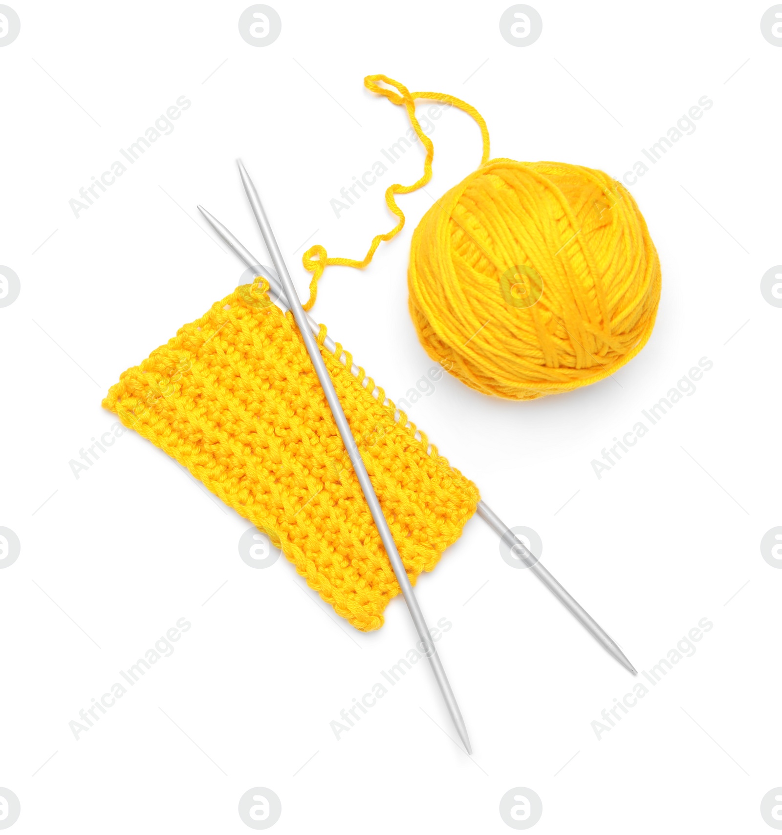 Photo of Soft yellow woolen yarn, knitting and metal needles on white background, top view