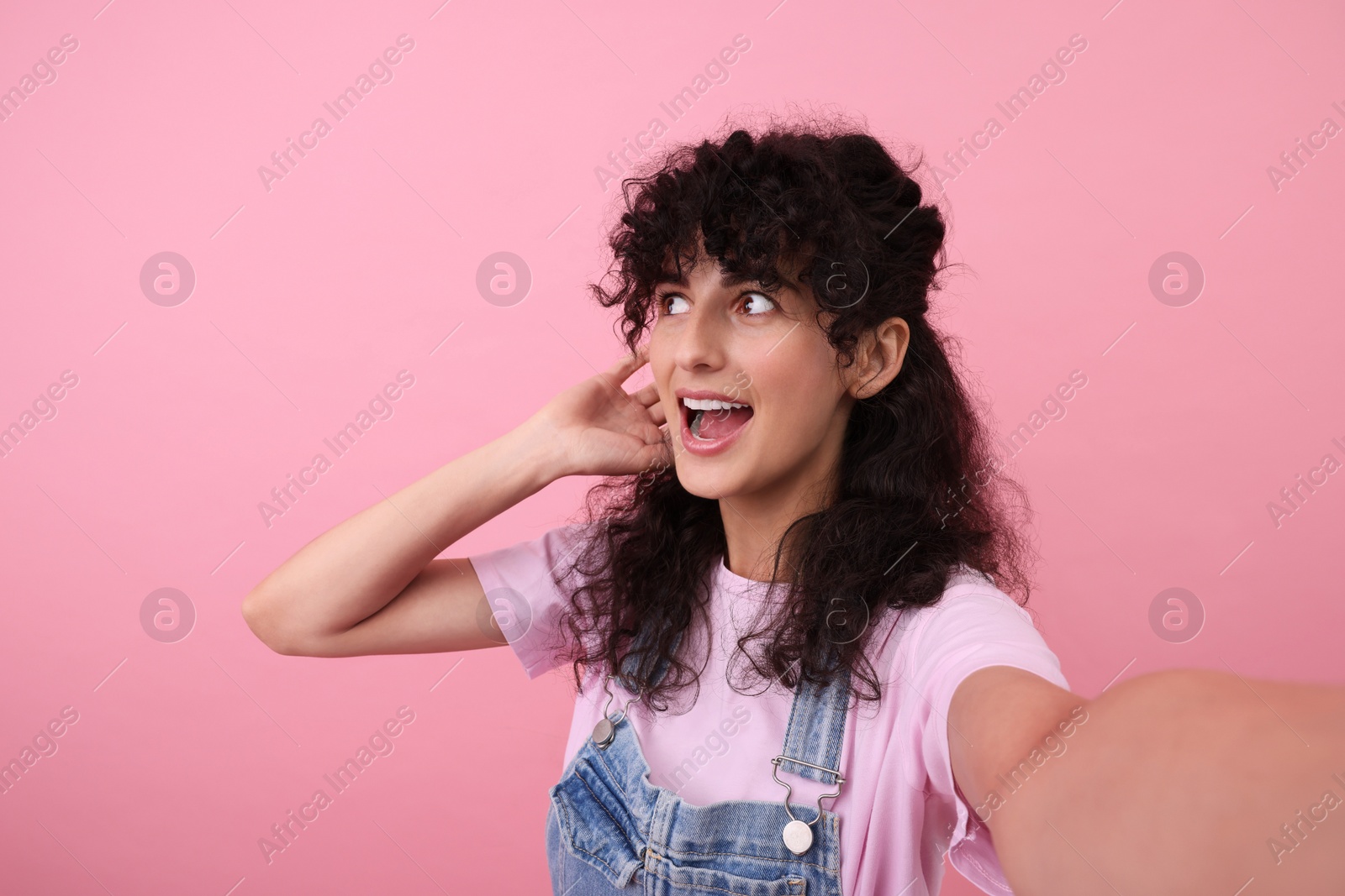 Photo of Beautiful woman taking selfie on pink background