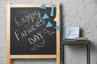 Chalkboard with phrase "Happy father's day" on brick wall background