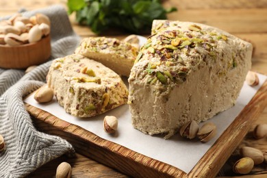 Photo of Tasty halva with pistachios on table, closeup