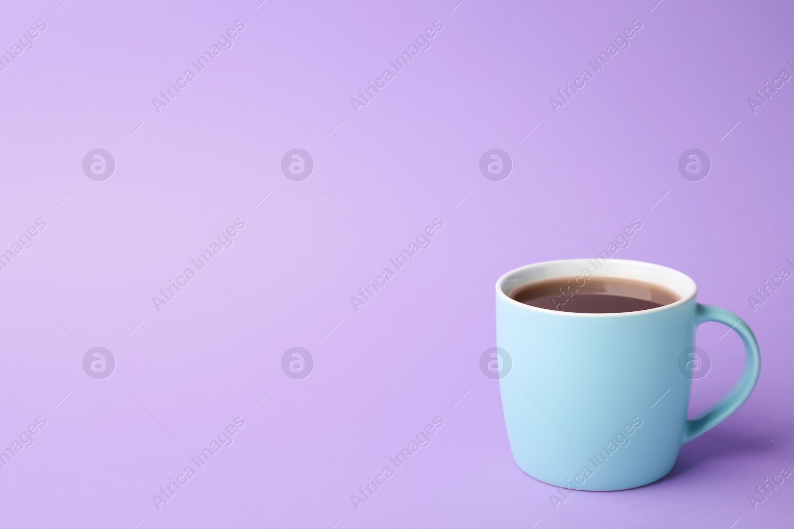 Photo of Blue ceramic cup with hot aromatic coffee on color background