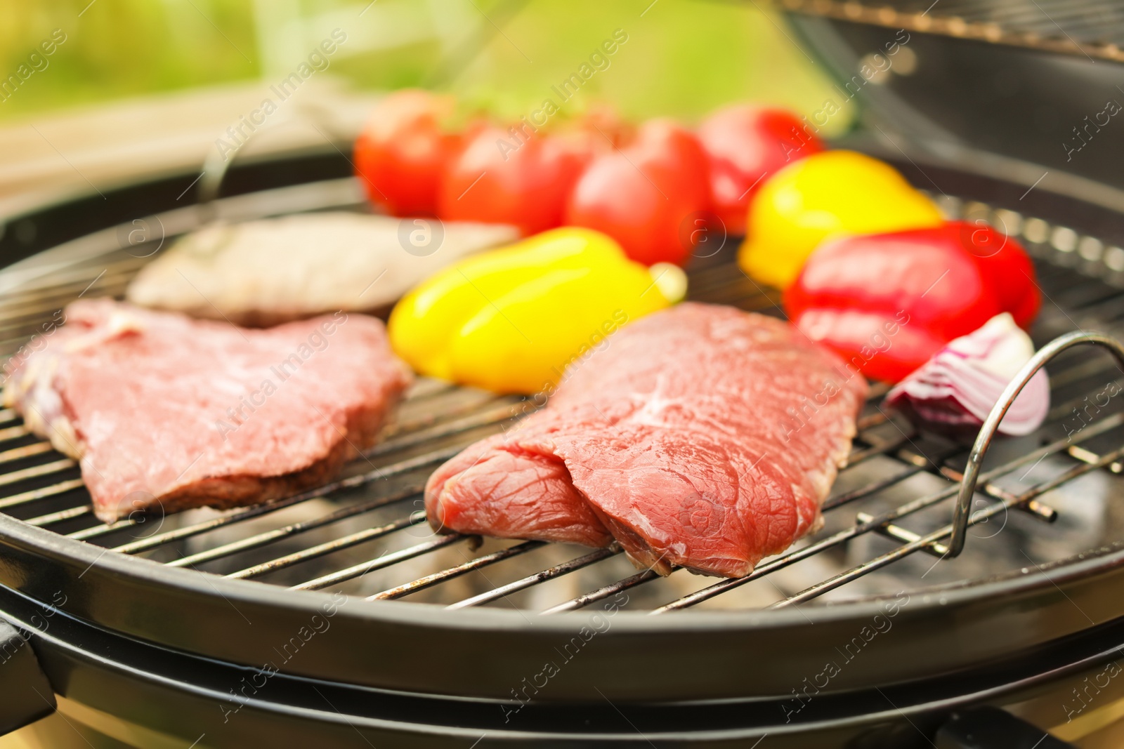 Photo of Modern grill with meat and vegetables outdoors, closeup