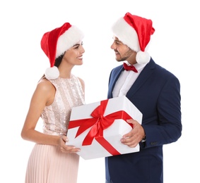 Photo of Lovely young couple in Santa hats with gift box on white background. Christmas celebration