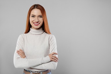 Portrait of beautiful young woman on light gray background, space for text