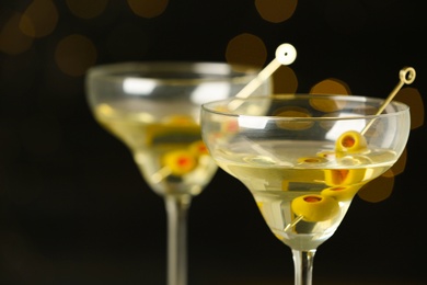 Glasses of Classic Dry Martini with olives against blurred background, closeup