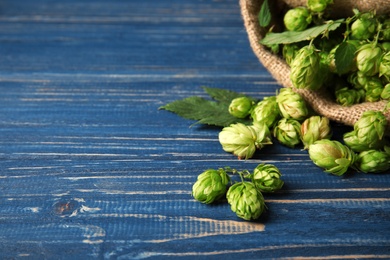 Photo of Fresh green hops and space for text on wooden table. Beer production