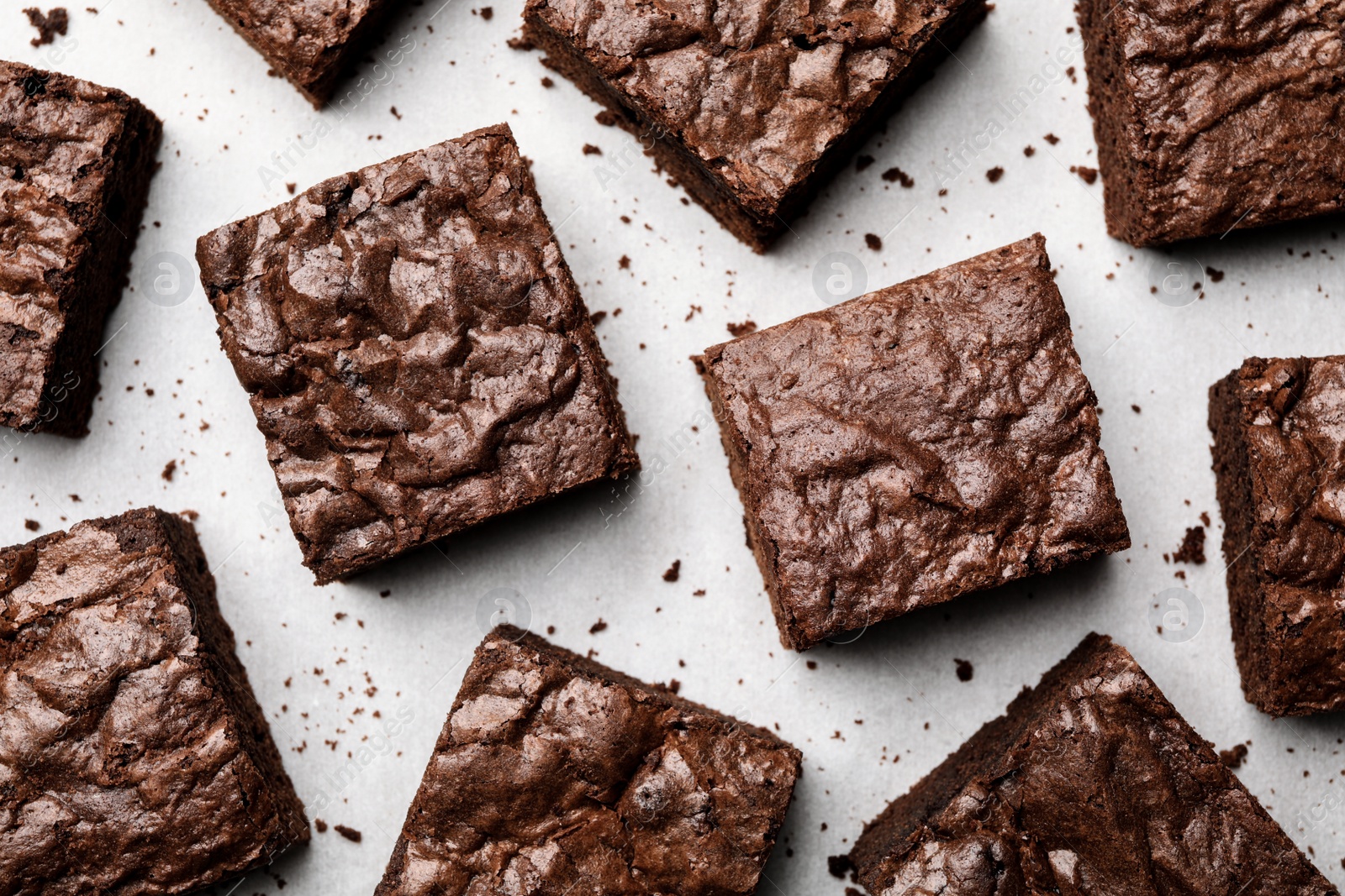 Photo of Flat lay composition with fresh brownies on parchment paper. Delicious chocolate pie