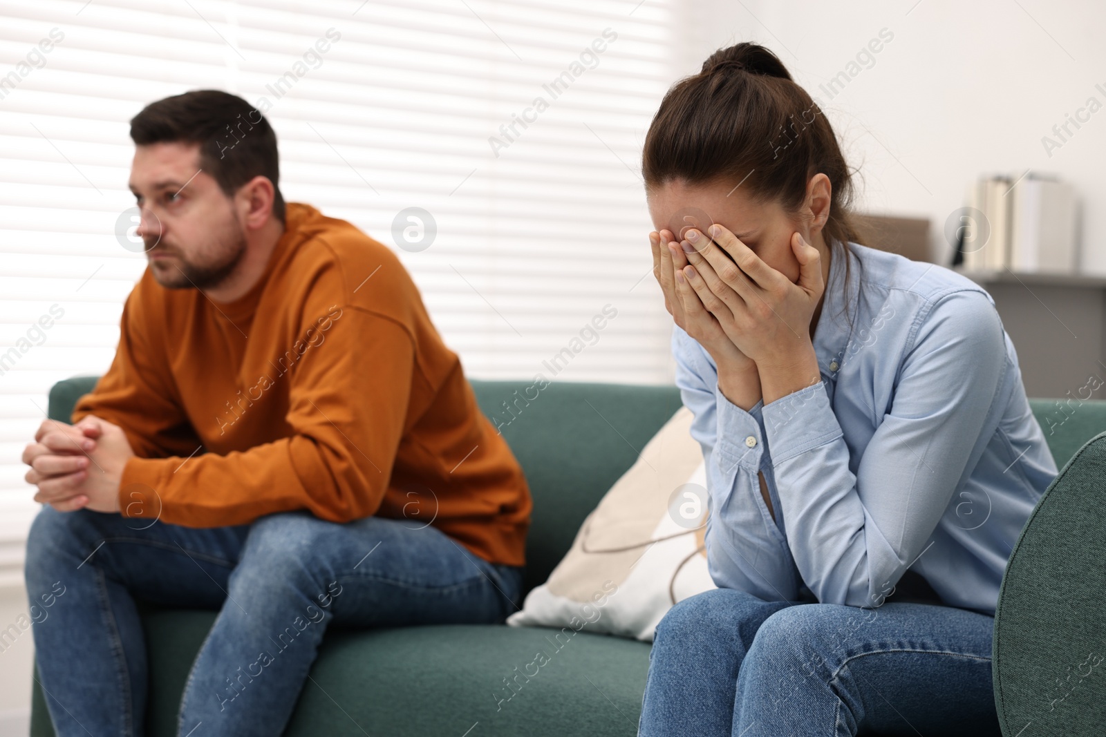 Photo of Offended couple ignoring each other after quarrel indoors, selective focus. Relationship problems