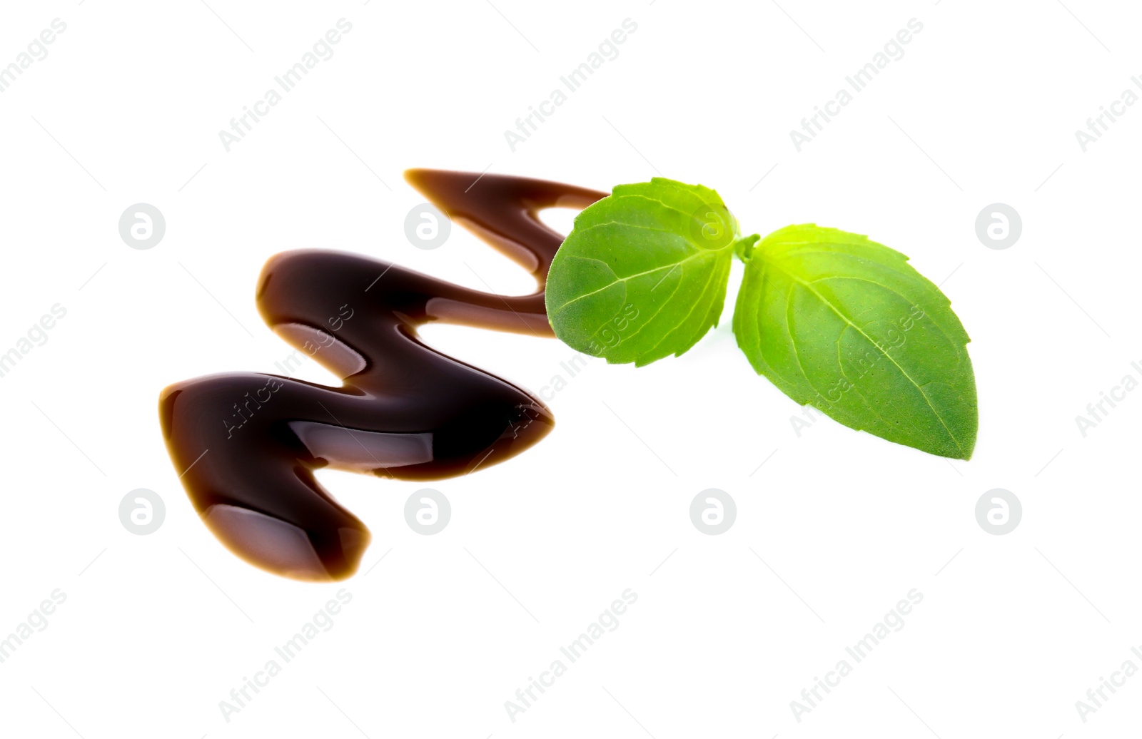 Photo of Balsamic glaze and basil leaves on white background