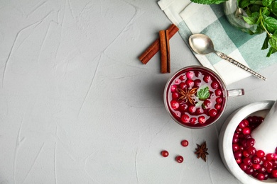 Photo of Tasty hot cranberry tea and fresh ingredients on light table, flat lay. Space for text