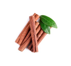 Photo of Cinnamon sticks and green leaves isolated on white, top view