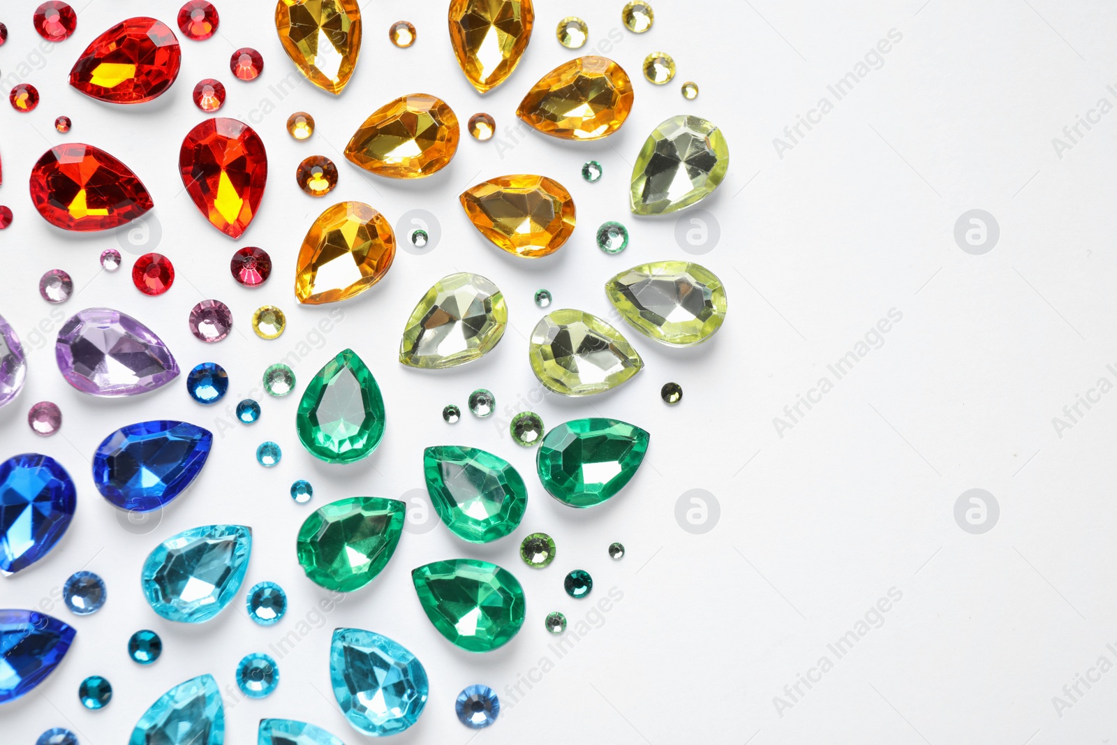 Photo of Different beautiful gemstones on white background, top view
