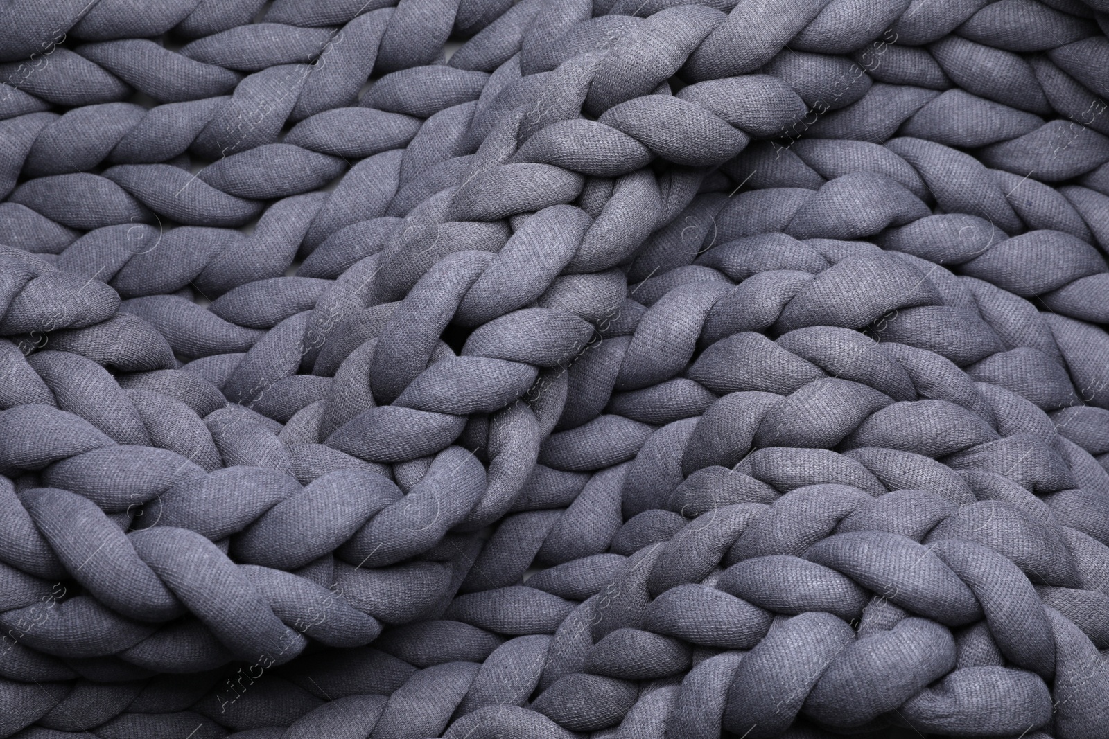 Photo of Top view of grey chunky knit blanket as background