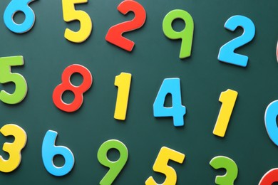 Photo of Colorful numbers on green background, flat lay