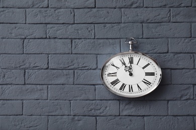 Photo of Modern clock on brick wall. Time concept