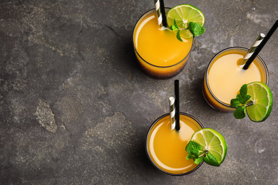 Fresh alcoholic Tequila Sunrise cocktails on grey table, flat lay. Space for text