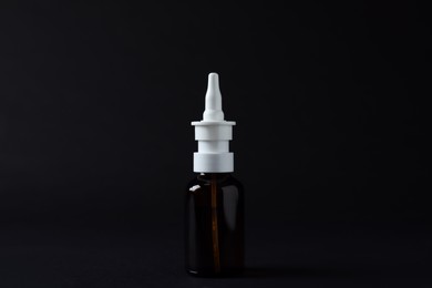 Photo of Bottle of nasal spray on black background