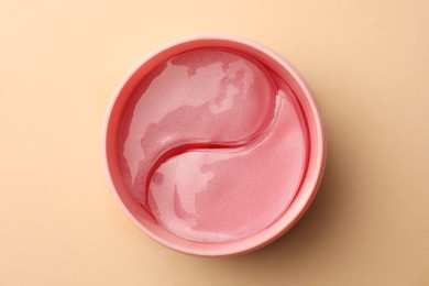Photo of Jar of under eye patches on beige background, top view. Cosmetic product