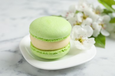 Green macaron and flowers on white marble table