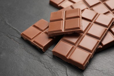 Delicious milk chocolate on black table, closeup