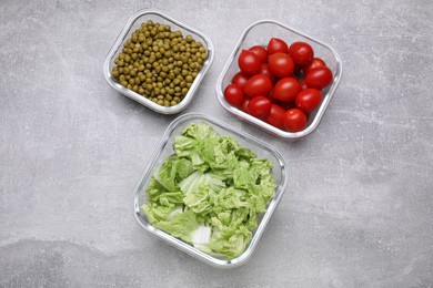 Glass containers with different fresh products on light grey table, flat lay