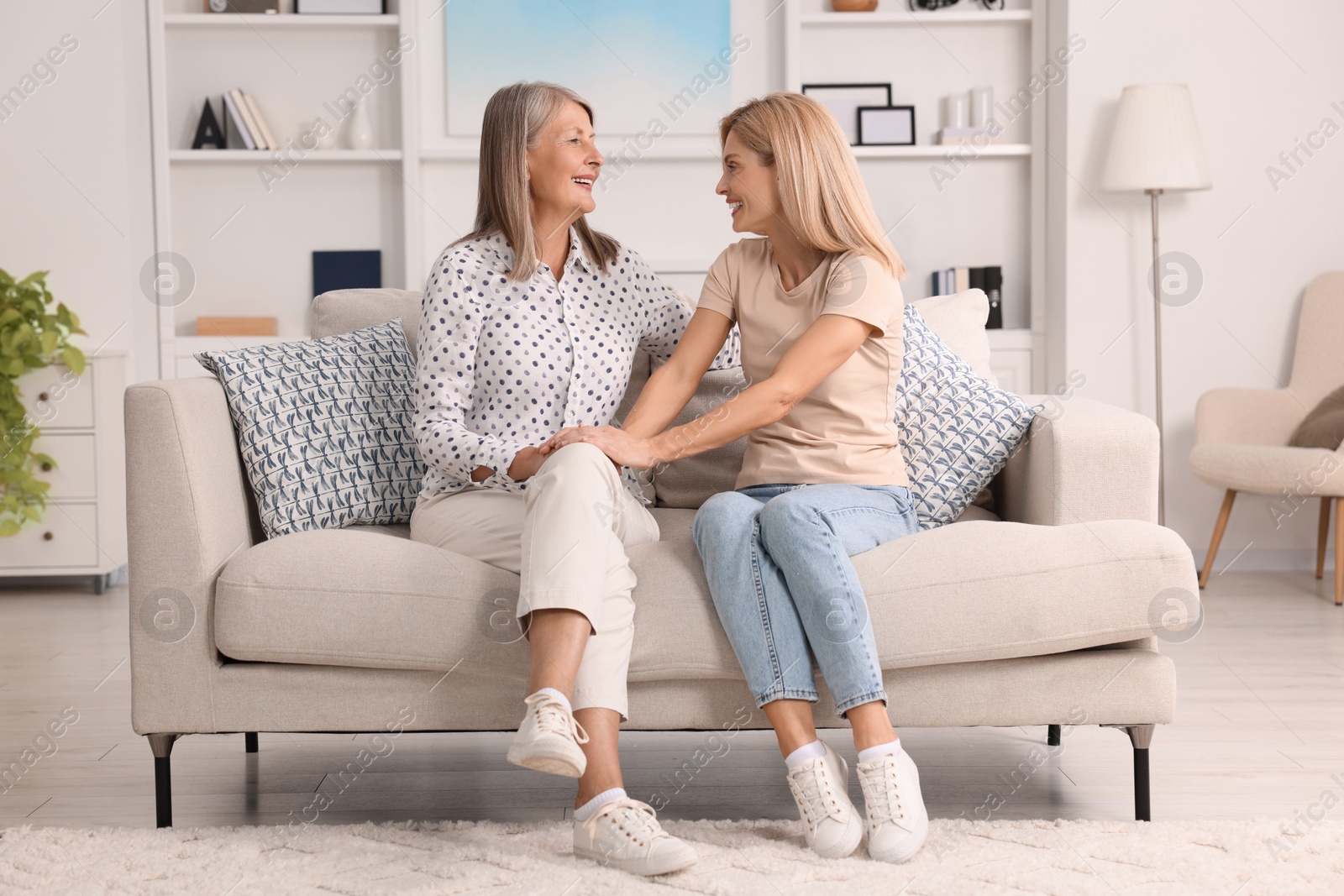 Photo of Happy mature mother and her daughter spending time together at home