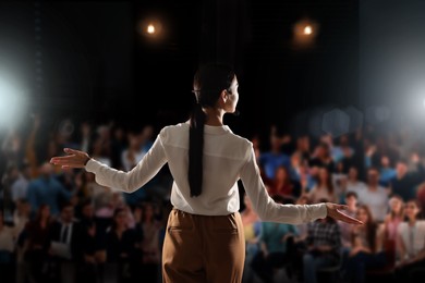 Image of Motivational speaker with headset performing on stage, back view
